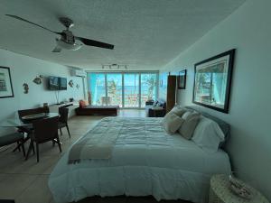 a bedroom with a large bed and a living room at Ocean view Studio Marina Lanais in Fajardo