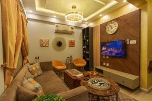 a living room with a couch and a clock on the wall at Murree Hills Executive 3 Bedroom Cottage with Scenic View in Murree
