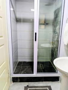 a shower with a glass door in a bathroom at Apartment near the University of Botswana in Gaborone