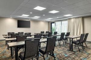 una sala de conferencias con mesas, sillas y una pantalla en Residence Inn Richmond Airport, en Sandston 33 fotos más