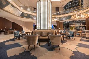 a hotel lobby with tables and chairs and a chandelier at InterContinental Lisbon by IHG in Lisbon