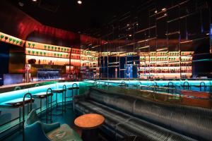 a bar with tables and stools in a room at InterContinental Lisbon by IHG in Lisbon