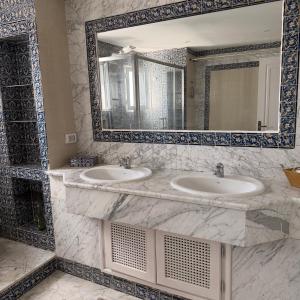 a bathroom with two sinks and a large mirror at Casaflor Tunis in Berges Du Lac +23 photos