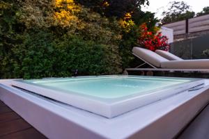 a bath tub sitting on a patio with two chairs at Dimora Botanica in Naples