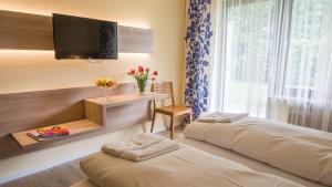慕尼黑的住宿－阿霍恩酒店，一间卧室设有两张床,墙上配有电视。