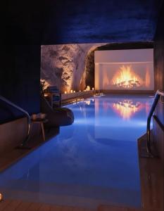 a swimming pool with a fireplace in a cave at Luxury Apartment with Sea and Skyline Views St Julians in St Julian's