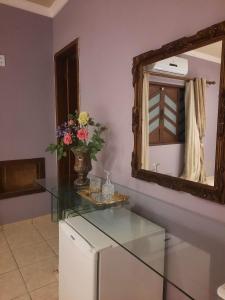 Cette chambre comprend une table en verre et un miroir. dans l'établissement Luz do Sol Pousada 700m Praia do Peró, à Cabo Frio 45 autres photos