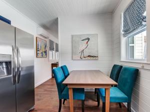 a dining room with a table and blue chairs at Beachside Villa Unit 5 in Tybee Island
