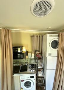 a small kitchen with a washer and dryer at Cosy & new CNZhouse with yard in Christchurch