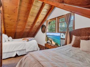 ein Schlafzimmer mit zwei Betten und einem großen Fenster in der Unterkunft Tahoe Classic Cabin Near the Beach in Stateline