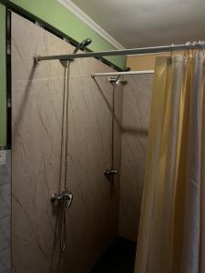 a bathroom with a shower and a shower curtain at Ankatu Hostel in El Bolsón +45 photos