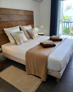 a bedroom with a large bed with a wooden headboard at Studio Le Sablé in Îlet à Christophe