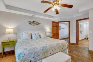 een slaapkamer met een bed en een plafondventilator bij Ocean Song 324 in Tybee Island +37 foto's