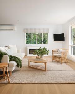 a living room with a couch and a table at Oak Ridge Cottage in Maleny