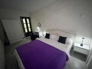 a bedroom with a large bed with a purple blanket at Апартаменты в центре города #2 in Aktobe