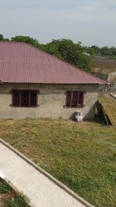 a small house with red windows and a roof at Rayana's Busura BnB in Brikama