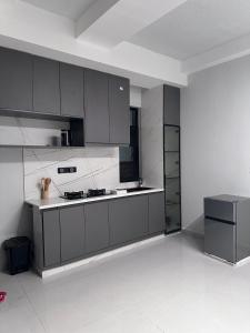 a kitchen with gray cabinets and a refrigerator at Breathtaking Nest 2, cosy and spacious in Kampala
