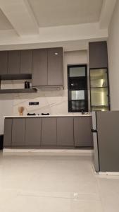 a large kitchen with gray cabinets and appliances at Breathtaking Nest 2, cosy and spacious in Kampala