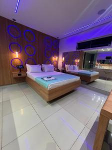 ein Schlafzimmer mit einem großen Bett mit violetter Beleuchtung in der Unterkunft A2 Motel Araras in Araras