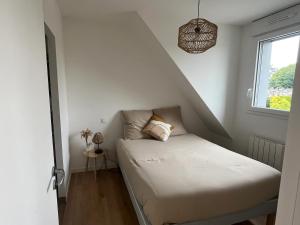 a small bed in a room with a window at Appartement confortable à Bruz de 22 m² avec parking in Bruz