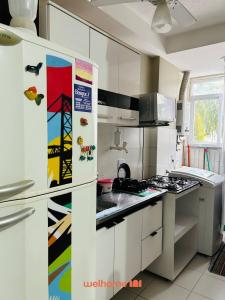 a kitchen with white cabinets and a refrigerator at Apartamento no Rio de Janeiro com Piscina e Lazer in Rio de Janeiro +20 photos