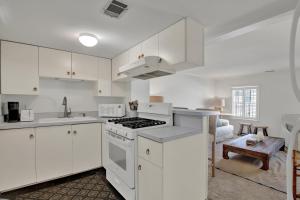 a kitchen with white cabinets and a stove top oven at Elsewhere on Madison Square Carriage House in Savannah
