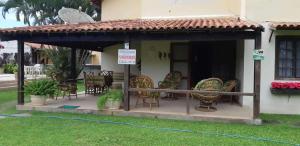 a patio with chairs and tables in a house at Casa em Cabo Frio com Piscina e Acesso a Praia in Tamoios