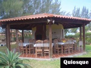 a wooden gazebo with a table and chairs at Casa em Cabo Frio com Piscina e Acesso a Praia in Tamoios