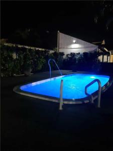 a blue swimming pool at night with a fountain at Casa em Cabo Frio com Piscina e Acesso a Praia in Tamoios