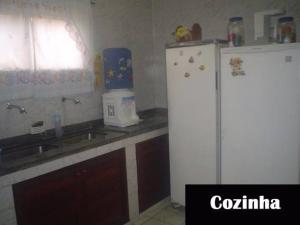 a kitchen with a white refrigerator and a sink at Casa em Cabo Frio com Piscina e Acesso a Praia in Tamoios +1 photo