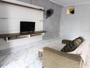 a living room with a couch and a tv at Apartment on the 3rd floor, 10 minutes from the beach, railway and bus station in Vila Velha