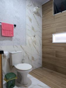 a bathroom with a toilet and a television in it at Apartment on the 3rd floor, 10 minutes from the beach, railway and bus station in Vila Velha +15 photos