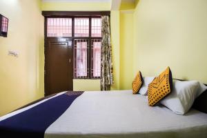 a bedroom with a bed with two pillows and a window at Collection O Hotel Kavya Guest House in Jaipur