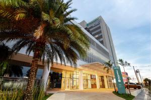 ロンドノポリスにあるNacional Inn Rondonópolisの前にヤシの木がある建物