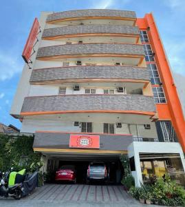 a tall building with cars parked in front of it at Stone House Hotel Pasay in Manila