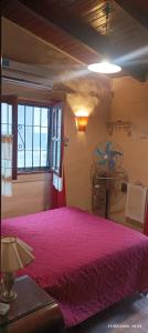ein Schlafzimmer mit einem rosa Bett und einem Fenster in der Unterkunft Casa de Campo Mama Lucia in Villa Anizacate