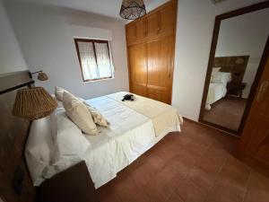 une chambre avec un lit blanc et un miroir dans l'établissement Casa Caldereta, à Ayelo de Rugat
