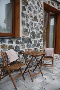 迪瓦伊巴雷DivčiNova LunaSol的石墙旁的一张木桌和椅子