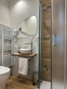 ein Badezimmer mit Waschbecken und Spiegel in der Unterkunft La Maison De Milan San Siro in Mailand + 32 Fotos