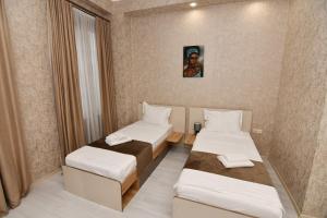 Pokój z dwoma łóżkami i zdjęciem na ścianie w obiekcie Astoria Hotel w mieście Zugdidi