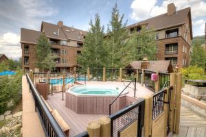 einen Whirlpool auf einer Terrasse mit einem Gebäude in der Unterkunft Arapahoe Lodge 8137 in Snake River Health Services Incorporated Heliport