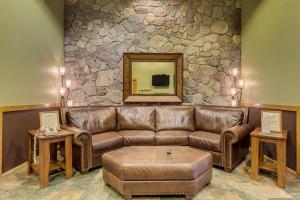 ein Wohnzimmer mit einer braunen Ledercouch und einem Spiegel in der Unterkunft Arapahoe Lodge 8137 in Snake River Health Services Incorporated Heliport + 22 Fotos