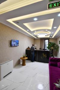 mężczyzna stojący przy ladzie w holu w obiekcie Astoria Hotel w mieście Zugdidi