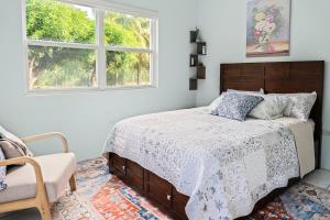 a bedroom with a bed and a chair and a window at Garden Apartment in Trinity