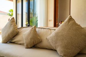 a group of pillows sitting on top of a couch at Casa Admire Villas in Legian