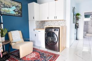 a washer and dryer in a kitchen with a chair at Garden Apartment in Trinity