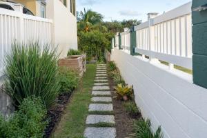 a walkway in the side of a building with plants at Garden Apartment in Trinity