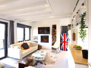 a living room with a white couch and a fireplace at Agathe in Laforêt