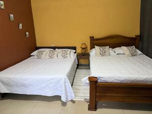 a bedroom with two beds with white sheets at Cabaña del Lago in Marsella