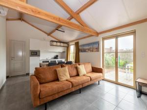 a living room with a brown couch and a kitchen at Westhinder I H19 in Koksijde